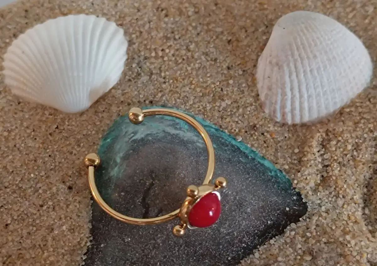 Bague dorée avec perle rouge